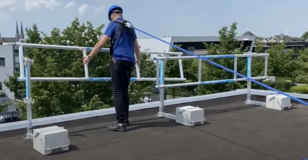 Operatore con sistema di protezione SGS su tetto, con parapetti e contrappesi